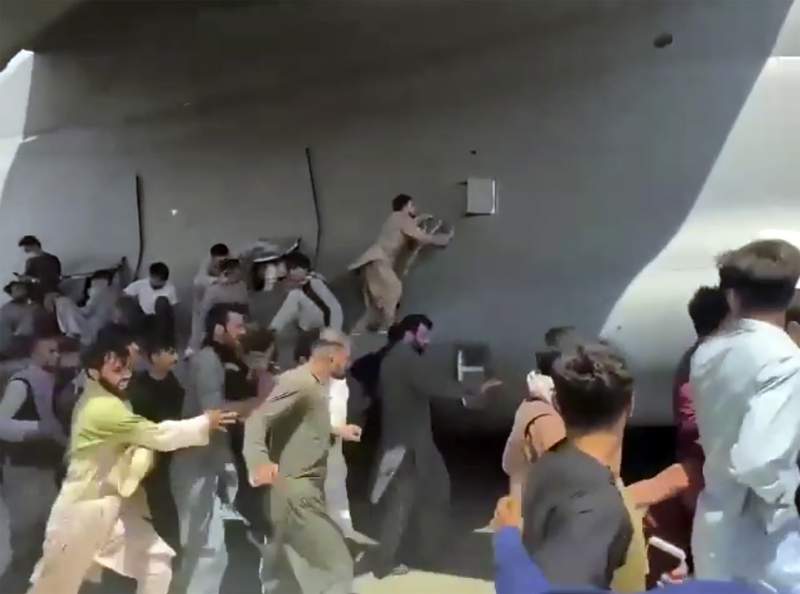 Video shows desperate Afghans climbing US jet to escape
